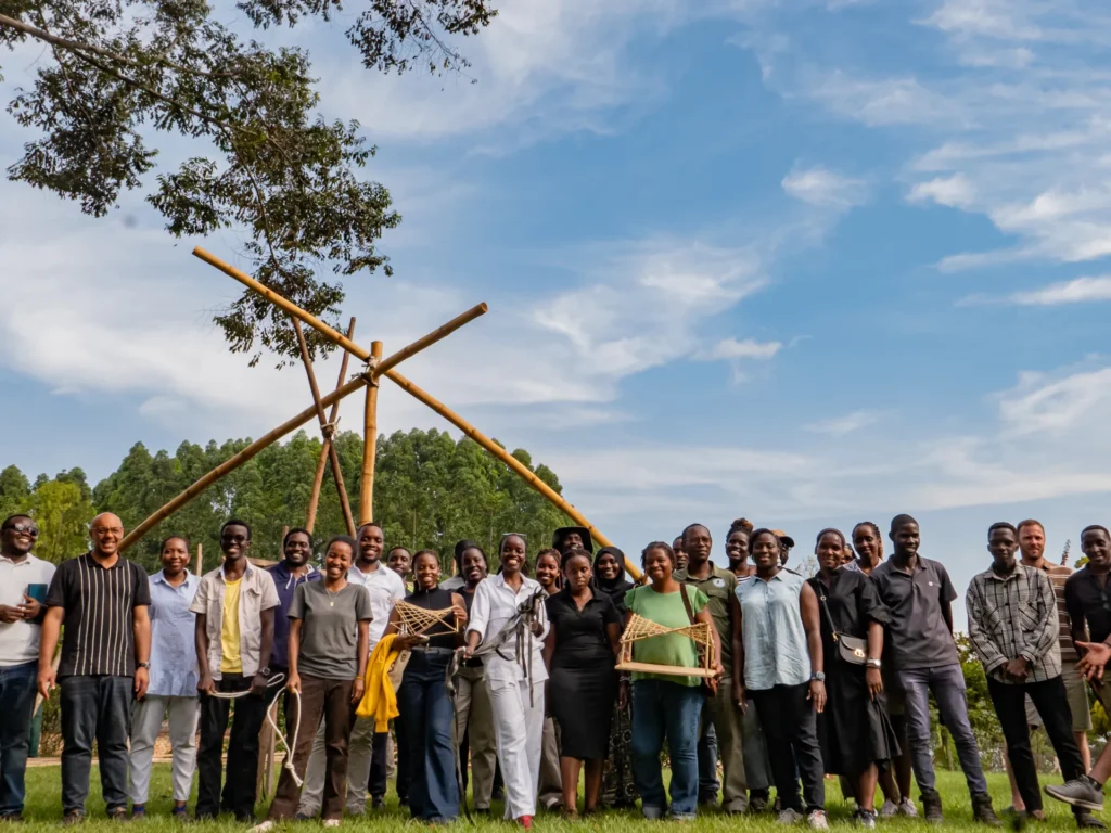 A group in a field under a bamboo frame